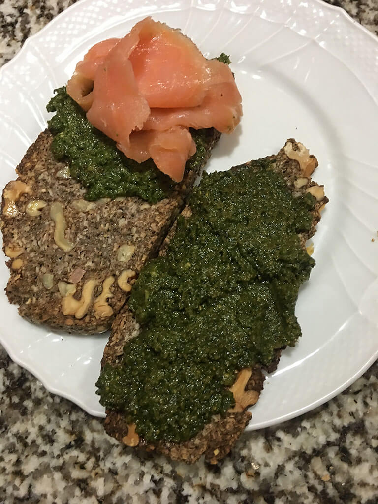 Slice of bread with basil pesto and smoked salmon