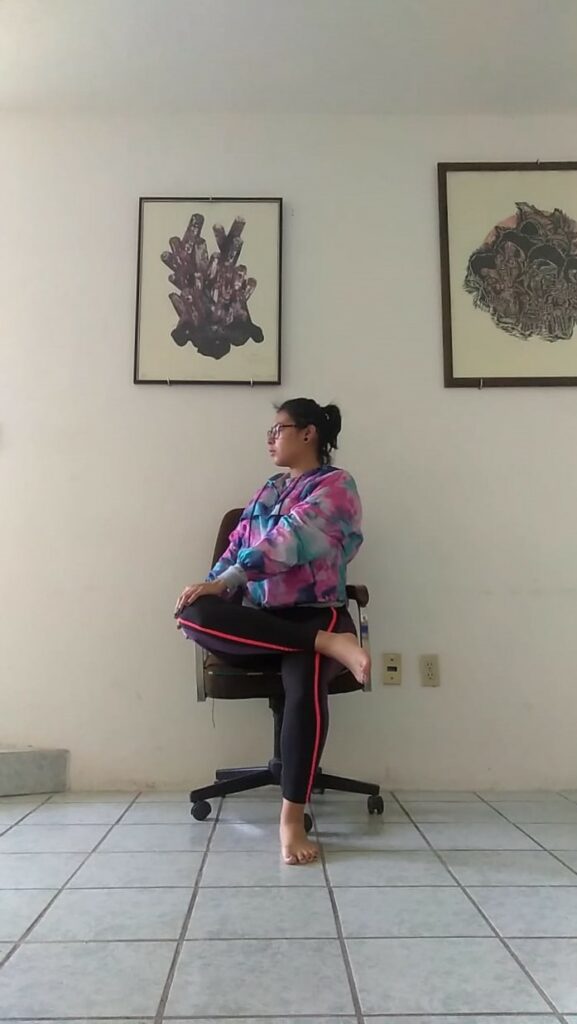 Woman doing yoga pose on chair
