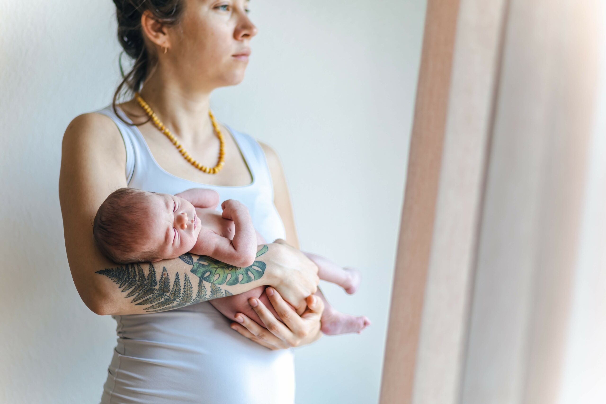 newborn-baby-in-the-arms-of-a-tired-mother-looking