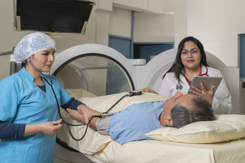 Doctors checking a patient next to a hyperbaric therapy machine.