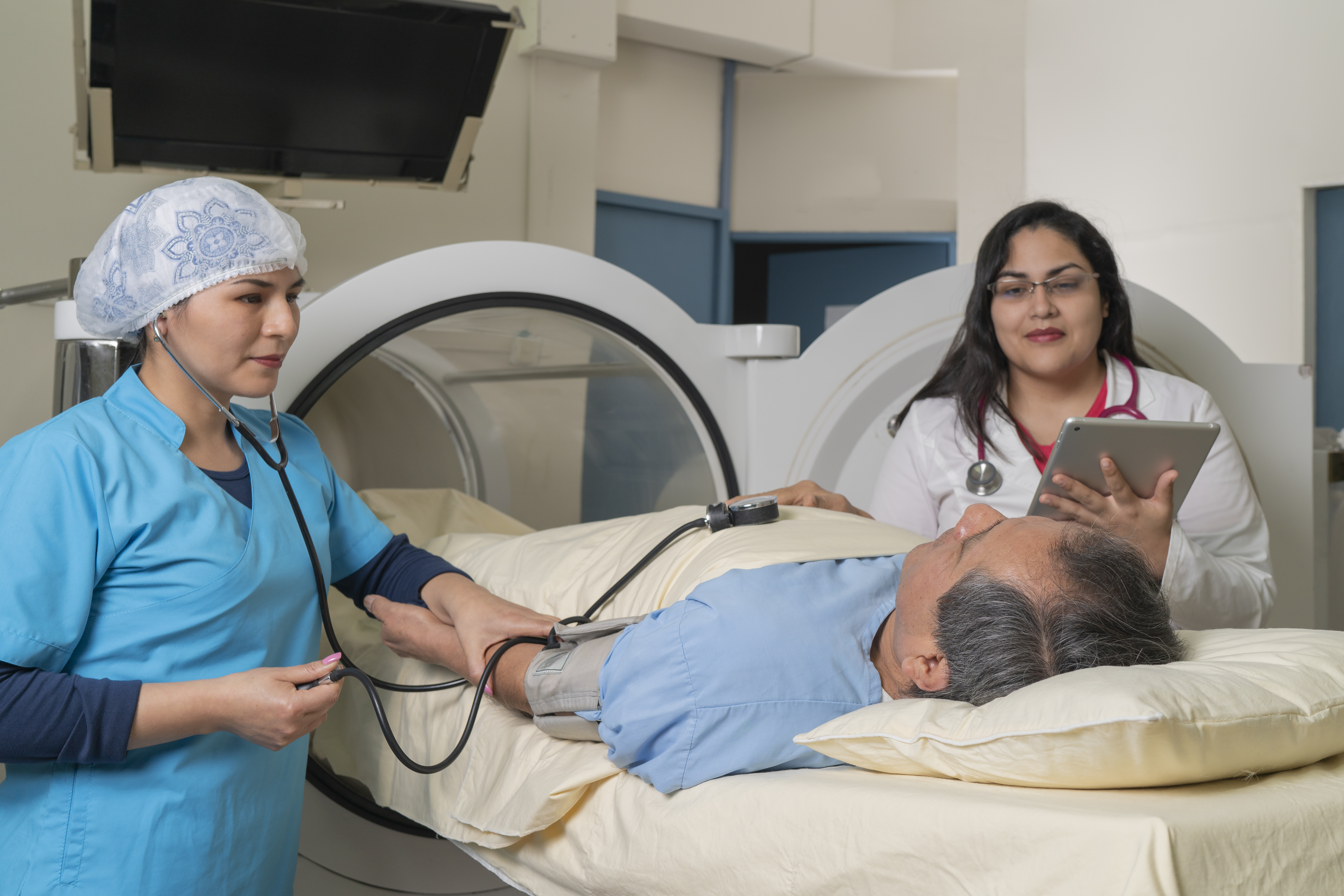 Doctors checking a patient next to a hyperbaric therapy machine.