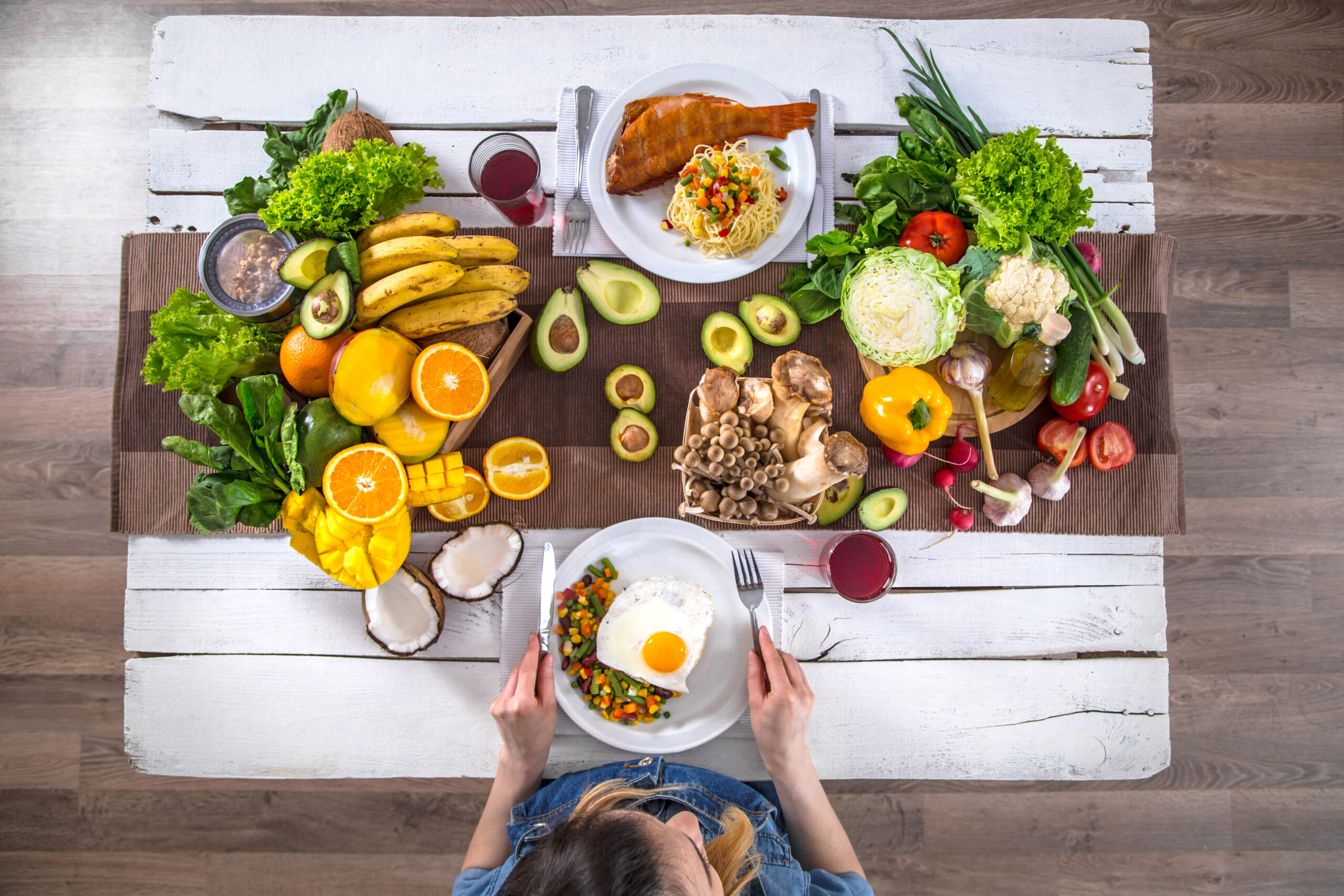 Woman at the dining table with a variety of organic healthy food , top view. The concept of healthy eating and celebration