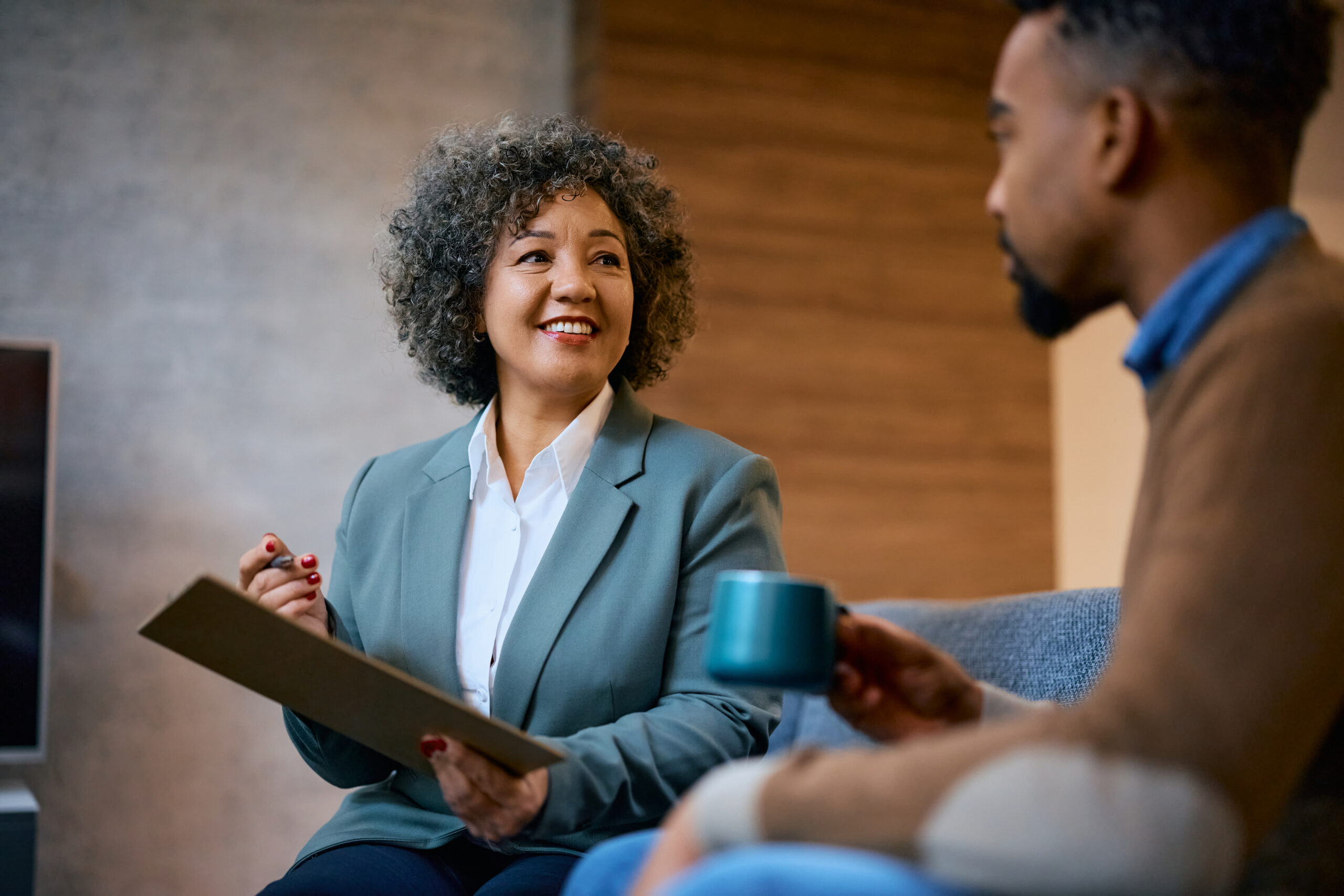 Happy financial advisor having a meeting with her client in the office.
