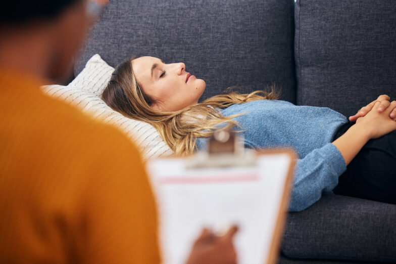 Relaxed woman on a couch during a hypnotherapy session