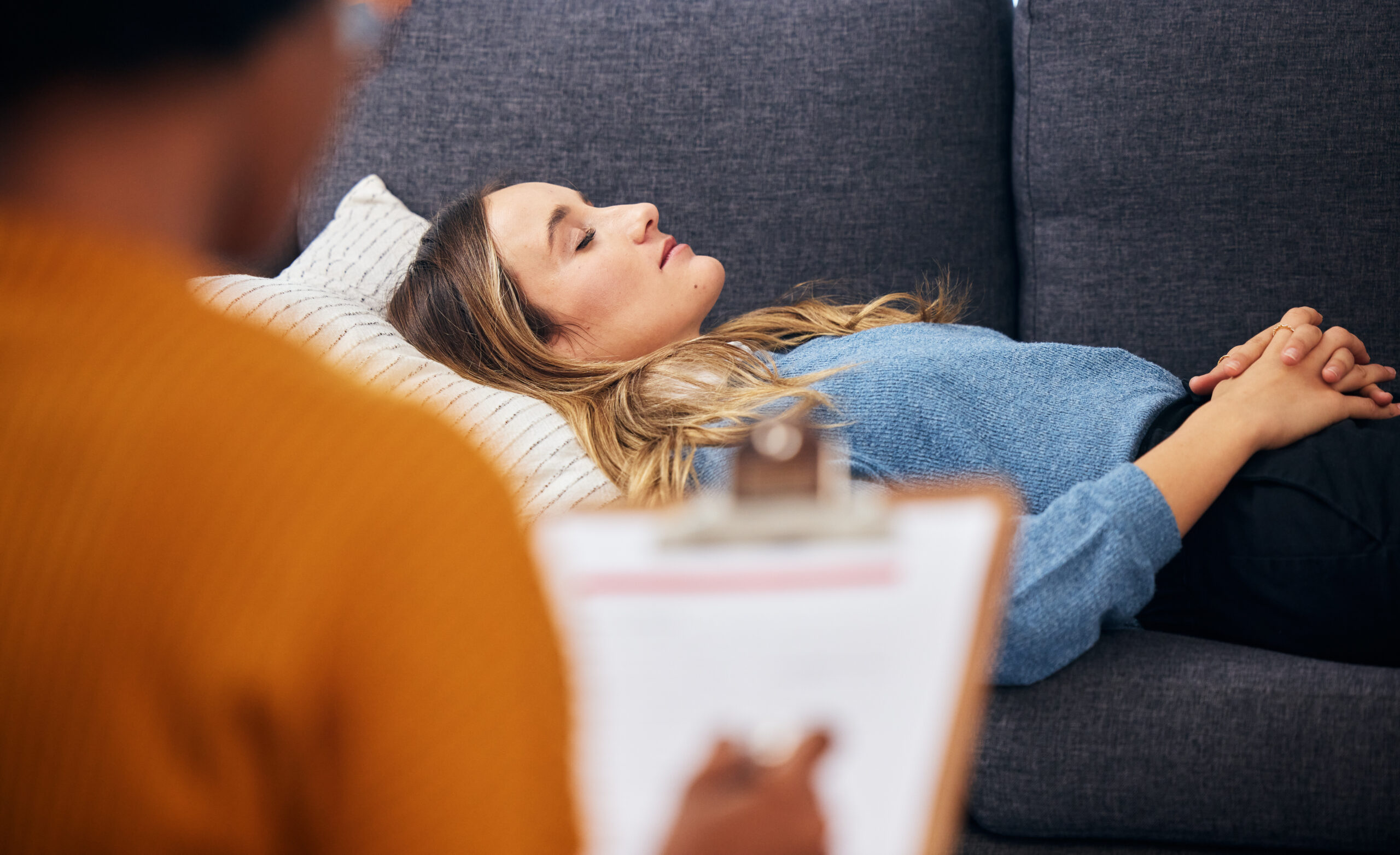 Relaxed woman on a couch during a hypnotherapy session
