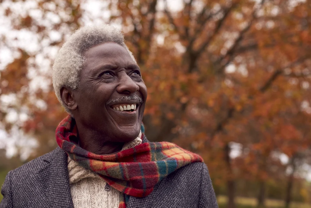 Man smiles while looking up toward the sky.